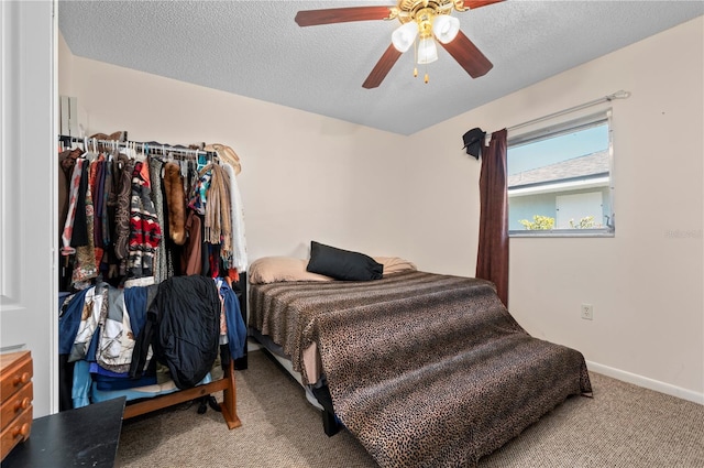 carpeted bedroom featuring ceiling fan and a textured ceiling