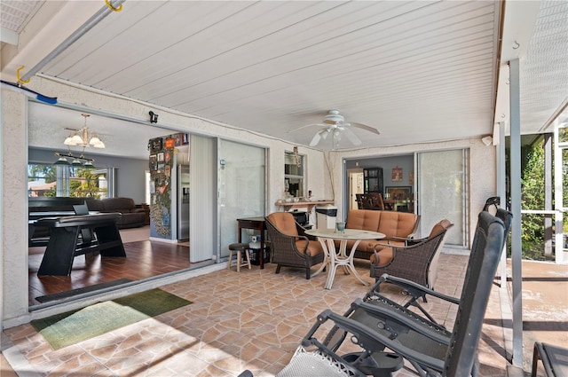 sunroom / solarium with ceiling fan with notable chandelier