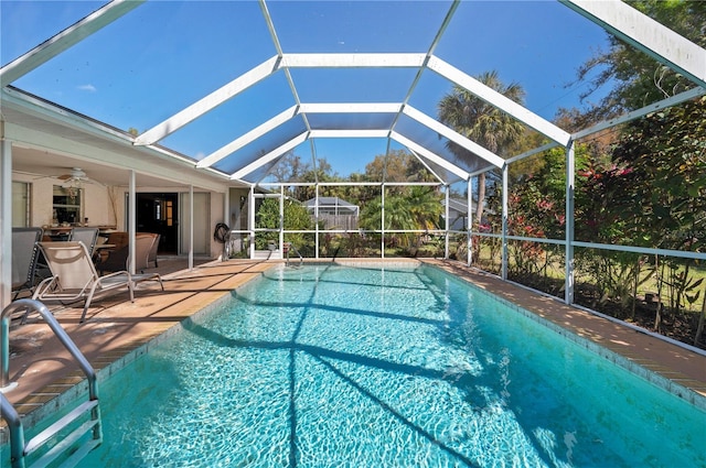 view of swimming pool with a patio, a lanai, and ceiling fan