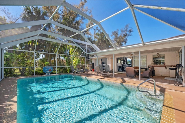 view of swimming pool with a patio, a lanai, and ceiling fan