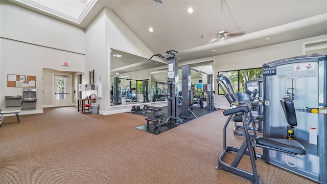 exercise room featuring ceiling fan, a healthy amount of sunlight, and high vaulted ceiling