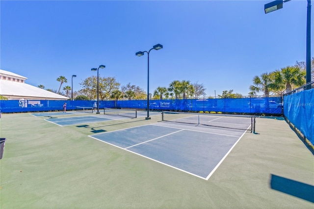 view of tennis court with basketball hoop