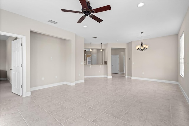 unfurnished living room featuring light tile patterned floors, a healthy amount of sunlight, and ceiling fan with notable chandelier