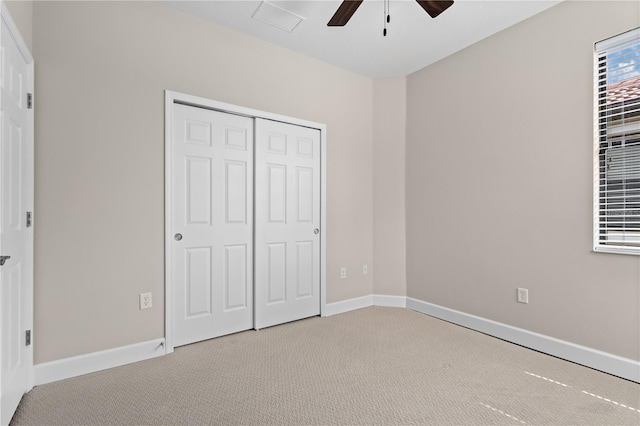 unfurnished bedroom with ceiling fan, a closet, and light carpet