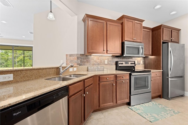 kitchen featuring stainless steel appliances, tasteful backsplash, sink, light stone counters, and light tile patterned floors