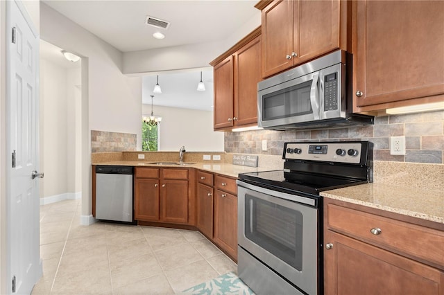 kitchen with light tile patterned floors, sink, pendant lighting, and appliances with stainless steel finishes