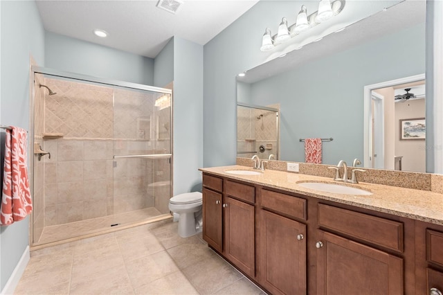 bathroom with toilet, vanity, a shower with door, and tile patterned floors