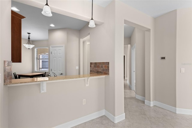 kitchen featuring pendant lighting, kitchen peninsula, and a breakfast bar area