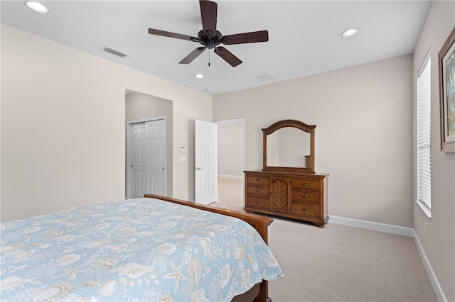 bedroom with ceiling fan, light colored carpet, and a closet