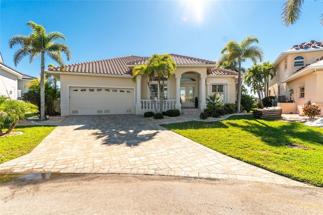 mediterranean / spanish house with a front lawn and a garage