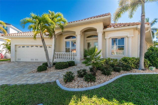 mediterranean / spanish-style home with a front yard and a garage