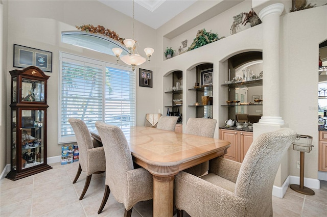 tiled dining room with a chandelier, built in shelves, and ornate columns