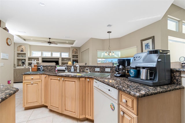 kitchen with hanging light fixtures, ceiling fan with notable chandelier, light tile flooring, white dishwasher, and a raised ceiling