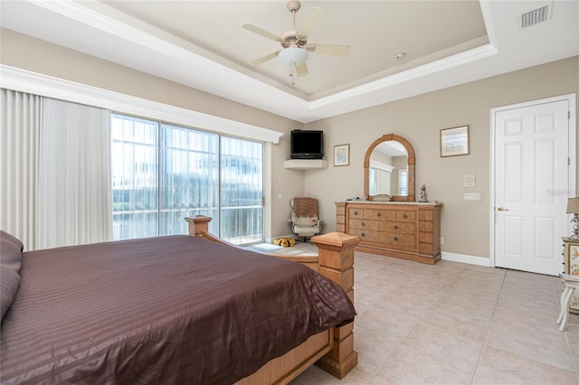 tiled bedroom with a tray ceiling and ceiling fan