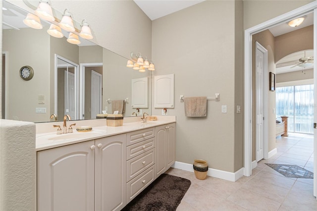 bathroom with double sink, tile flooring, vanity with extensive cabinet space, and ceiling fan