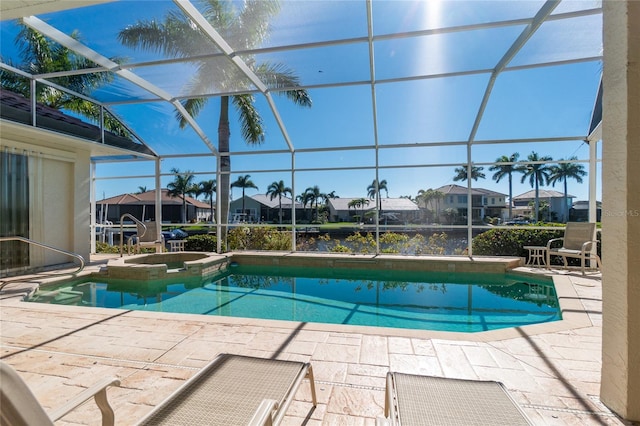 view of swimming pool with a patio, an in ground hot tub, and a lanai