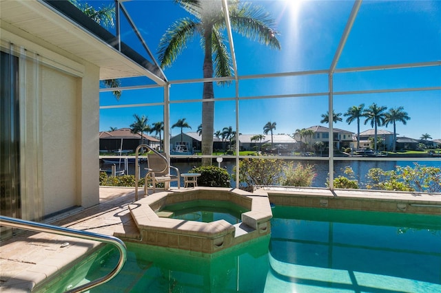 view of pool with a water view, an in ground hot tub, and a lanai