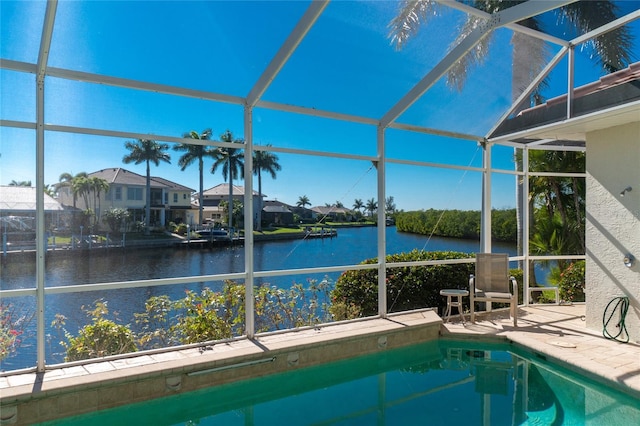 view of swimming pool featuring glass enclosure and a water view