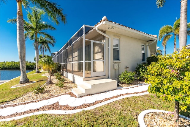 view of front of home featuring a front yard and glass enclosure