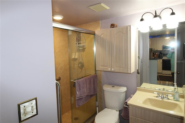 bathroom with a shower with shower door, toilet, and vanity