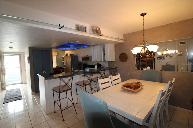 tiled dining area featuring a chandelier