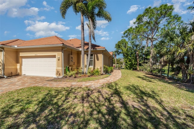 mediterranean / spanish home featuring a garage and a front lawn