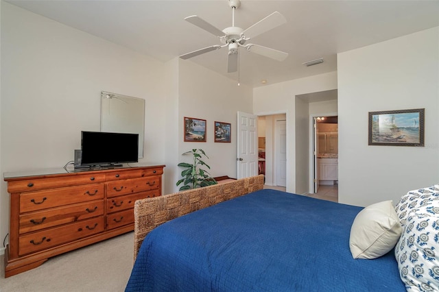 carpeted bedroom with ensuite bathroom and ceiling fan