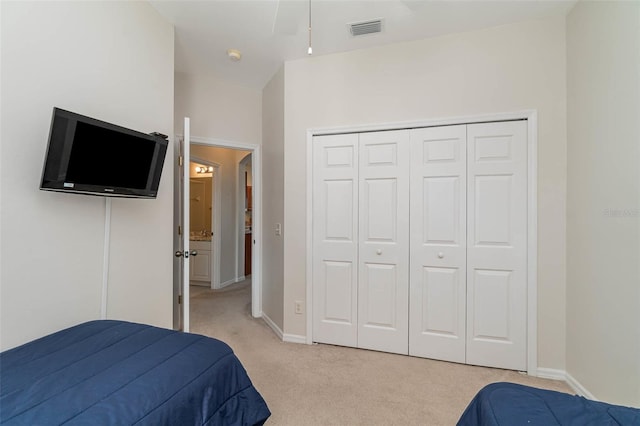 bedroom featuring light carpet and a closet