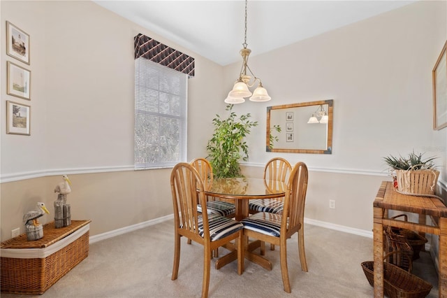 dining area with light colored carpet and a chandelier