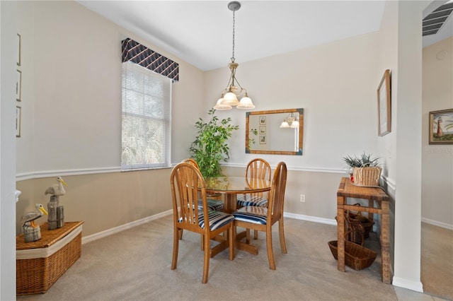 dining area featuring light colored carpet and an inviting chandelier