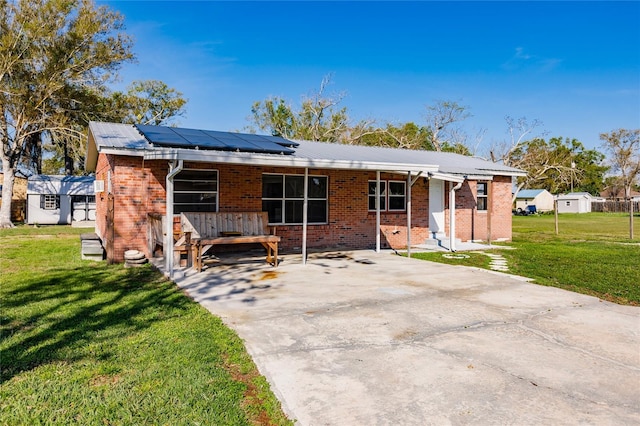 view of front facade featuring solar panels and a front lawn