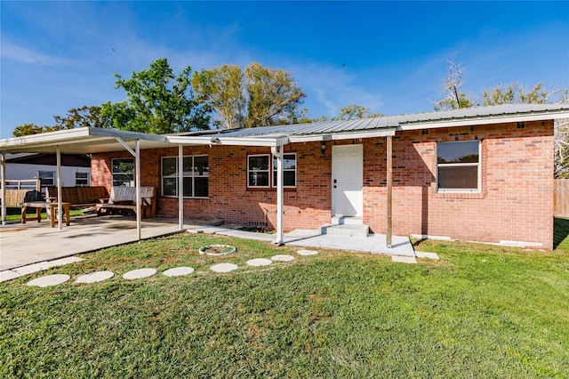 rear view of house with a patio and a yard