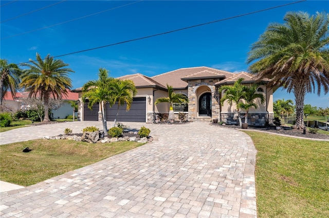 mediterranean / spanish-style home featuring a front lawn and a garage