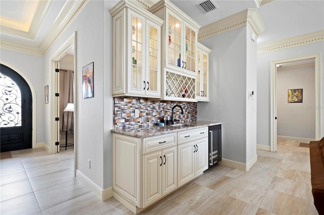 interior space featuring a raised ceiling, sink, and crown molding