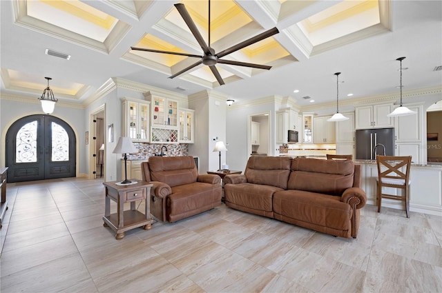 tiled living room featuring coffered ceiling, crown molding, french doors, and beamed ceiling