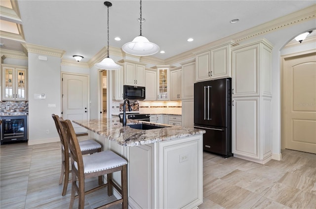 kitchen with light stone countertops, black appliances, wine cooler, tasteful backsplash, and pendant lighting