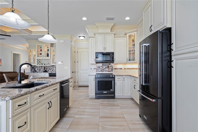 kitchen with light stone countertops, tasteful backsplash, black appliances, hanging light fixtures, and sink