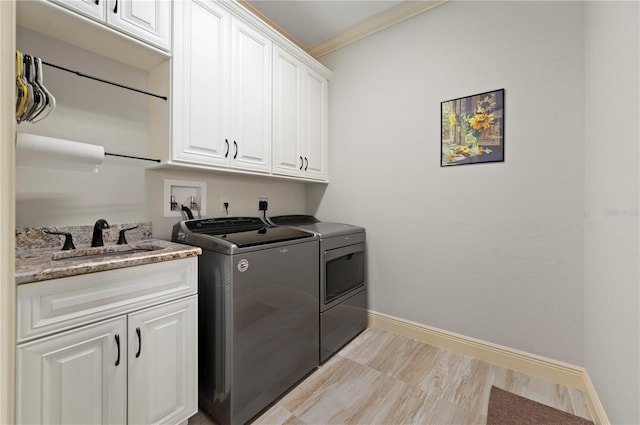 washroom with hookup for an electric dryer, independent washer and dryer, ornamental molding, cabinets, and light wood-type flooring