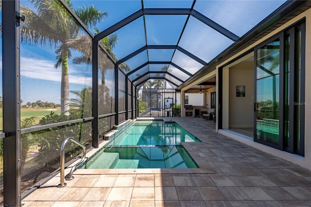 view of swimming pool with a patio area, ceiling fan, and a lanai