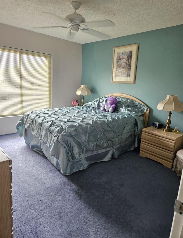 carpeted bedroom with ceiling fan and a textured ceiling