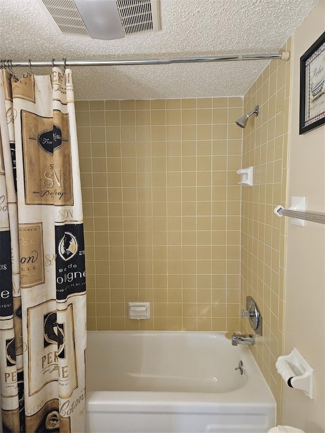 bathroom featuring a textured ceiling and shower / bath combo