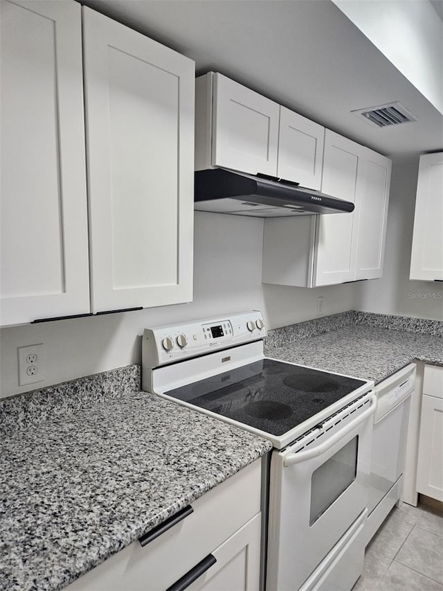 21280 Brinson Ave Unit 205, Port Charlotte, FL 33952 - kitchen with visible vents, under cabinet range hood, light stone counters, white cabinetry, and white appliances