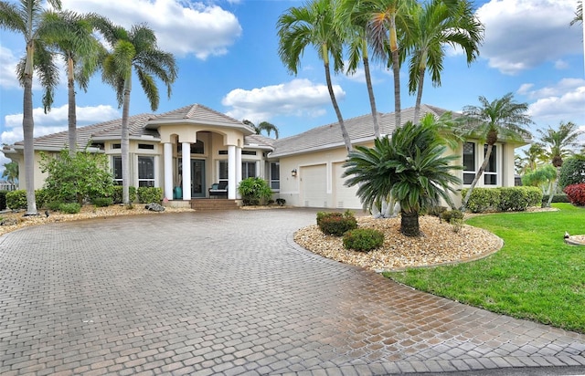 mediterranean / spanish home featuring a front lawn and a garage