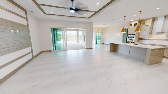 kitchen featuring light tile floors, ceiling fan, a kitchen island with sink, and decorative light fixtures