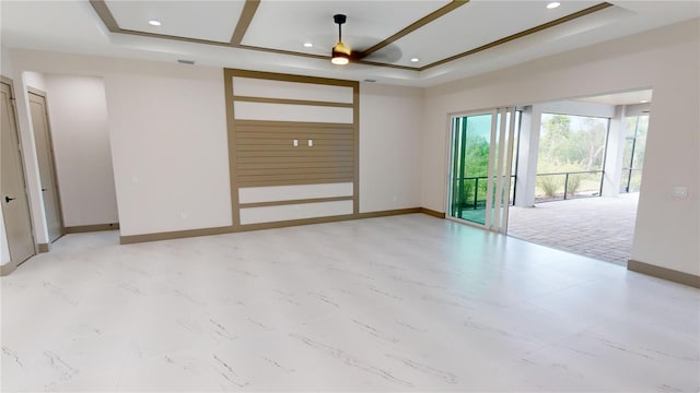 tiled spare room featuring ceiling fan and a tray ceiling