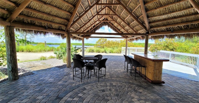 view of patio / terrace featuring a gazebo, a water view, and exterior bar