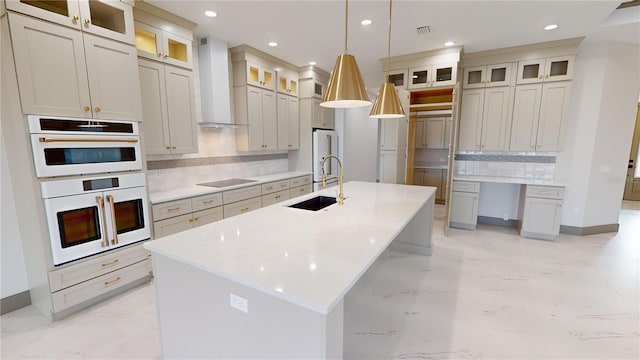 kitchen featuring backsplash, sink, light tile floors, wall chimney range hood, and pendant lighting