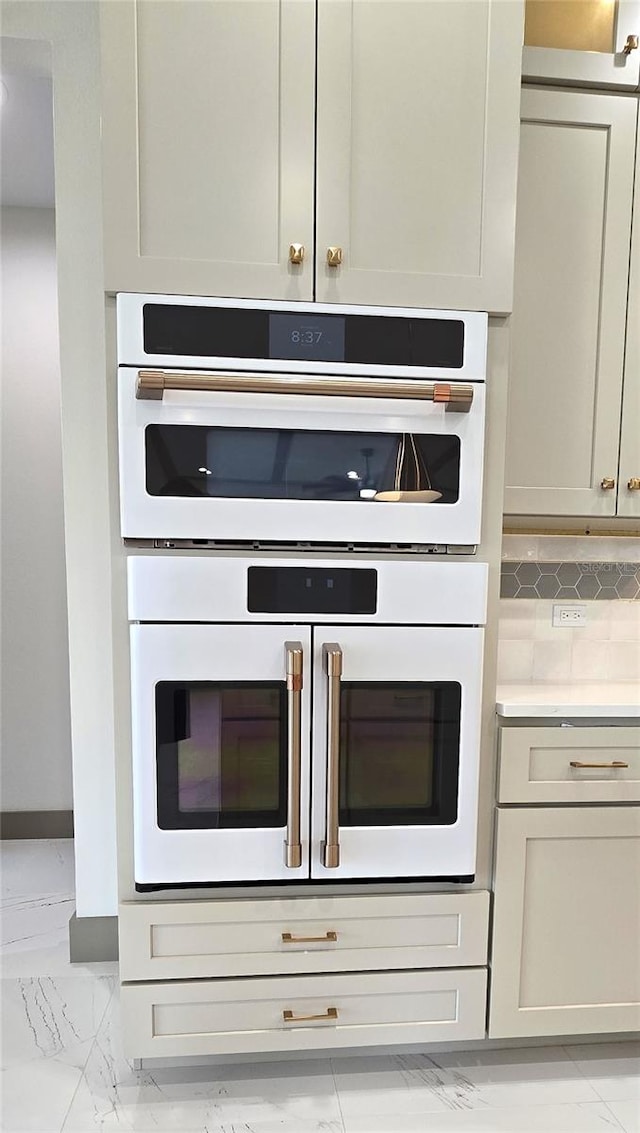 kitchen featuring light tile floors and white double oven