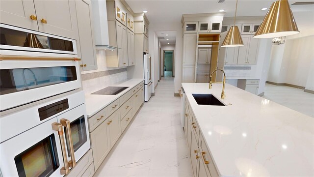 kitchen featuring decorative light fixtures, backsplash, white appliances, sink, and light stone counters