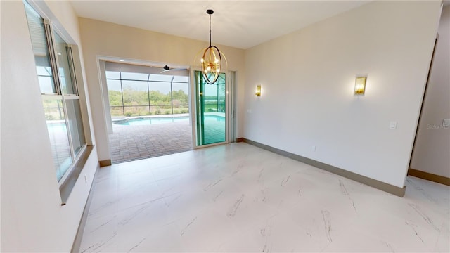 tiled empty room featuring a chandelier